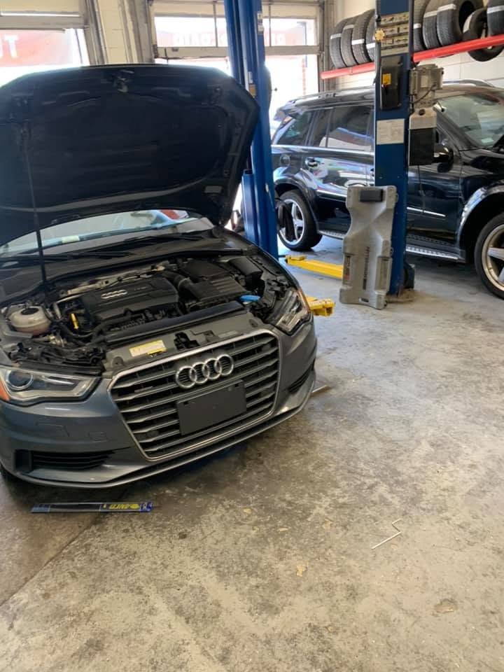 An Audi with its hood open on the shop floor at BMW Experts LLC