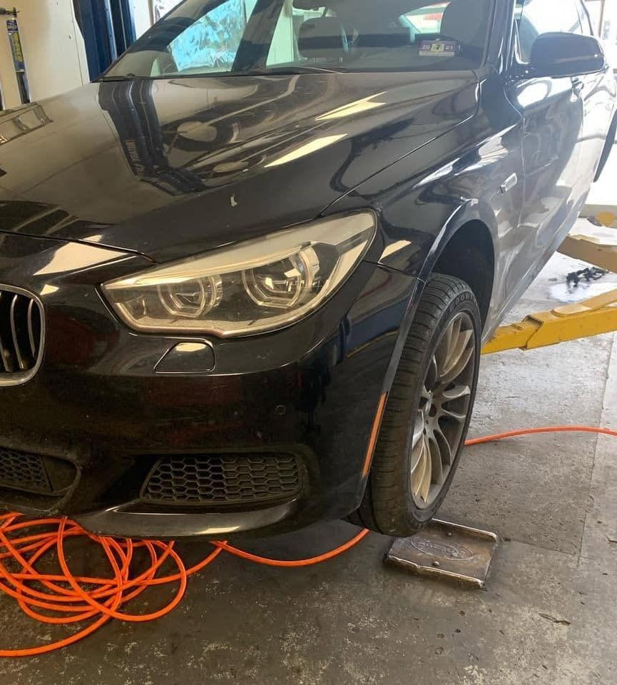 A BMW up on an alignment lift at BMW Experts LLC